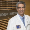 Photograph of Sairam Parthasarathy, MD, standing in front of Dept of Medicine